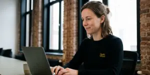 Bella, de chatassistente van Studio Ubique, typt een antwoord in de websitechat op een laptop