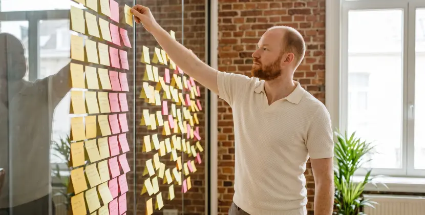 Close-up of a campaign manager pausing a Performance Max campaign while a keyword report stays open on the second screen