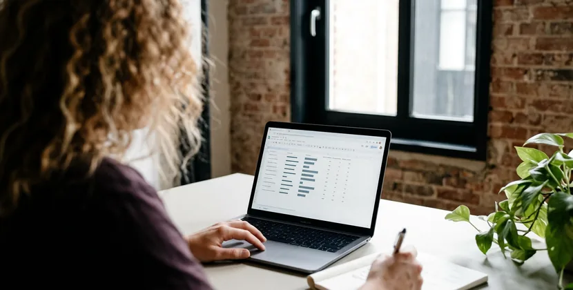 Seller at a kitchen table working out monthly commission against ad costs in a notebook