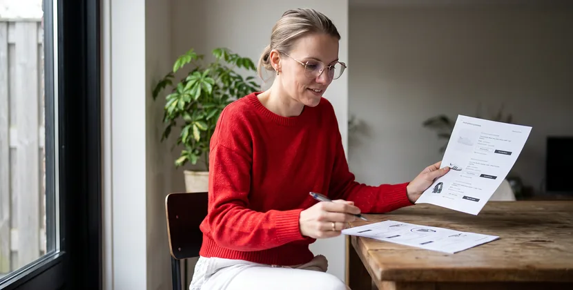 Person comparing printed product pages and circling a duplicate entry with a pen